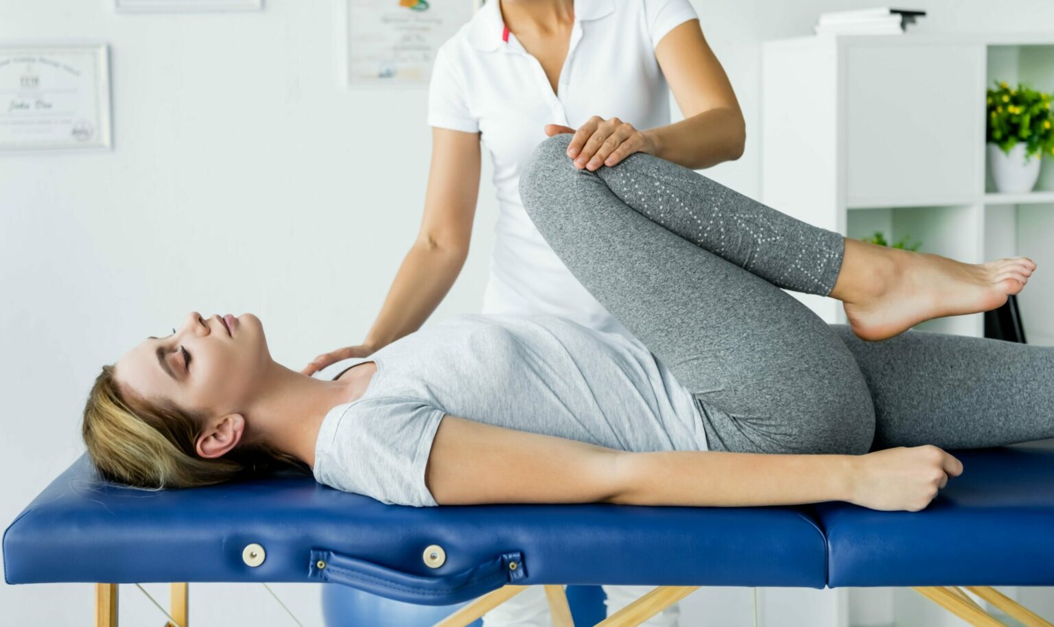 chiropractor touching leg of attractive patient in 2023 01 06 02 01 06 utc scaled e1682593309718